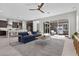 Open-concept living room with a ceiling fan, modern furniture, and access to the backyard at 18 Via Tiberina, Henderson, NV 89011