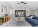 Bright living room featuring a modern decor, large sofa, and sliding glass doors opening to a beautifully landscaped patio at 18 Via Tiberina, Henderson, NV 89011