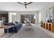 Spacious living room with a ceiling fan, large windows, and a cozy couch at 18 Via Tiberina, Henderson, NV 89011