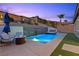 Inviting backyard pool and spa with waterfall feature, surrounded by a patio, lounge chairs, and landscaped hillside at 18 Via Tiberina, Henderson, NV 89011
