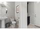 Charming powder room with pedestal sink, tiled floors, and decorative wall art at 18 Via Tiberina, Henderson, NV 89011