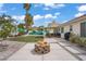 Landscaped backyard featuring an outdoor fire pit, patio, and artificial grass at 1830 Ginger Blossom Ave, North Las Vegas, NV 89031