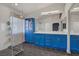 Vibrant bathroom featuring dual sinks, bold blue cabinetry, and a spacious glass-enclosed shower at 1830 Ginger Blossom Ave, North Las Vegas, NV 89031