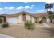 Charming single-story home featuring a tile roof, arched entryway, and desert landscaping at 1830 Ginger Blossom Ave, North Las Vegas, NV 89031
