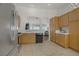 Well-equipped kitchen featuring wooden cabinetry, tile flooring, stainless steel appliances and seamless access to the living room at 1830 Ginger Blossom Ave, North Las Vegas, NV 89031