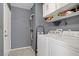 Neat laundry room features washer, dryer, storage shelves, and cleaning supplies at 1830 Ginger Blossom Ave, North Las Vegas, NV 89031