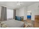 Bright primary bedroom features a ceiling fan, a large window with nice curtains, and wood-look floors at 1830 Ginger Blossom Ave, North Las Vegas, NV 89031