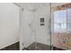 Stylish glass shower stall featuring white tiling, black hexagon flooring, and modern fixtures at 1830 Ginger Blossom Ave, North Las Vegas, NV 89031