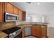 Modern kitchen with wooden cabinets, granite countertops, and stainless steel appliances at 2260 Village Walk Dr # 1305, Henderson, NV 89052