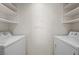 Bright laundry room featuring white washer and dryer units with white shelves at 2260 Village Walk Dr # 1305, Henderson, NV 89052