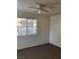 A simple bedroom featuring a ceiling fan, bright windows, and neutral carpeting at 230 Mission Catalina Ln # 204, Las Vegas, NV 89107