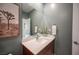 Stylish powder room featuring a modern vanity, textured walls, and a framed desert landscape artwork, exuding a calming ambiance at 2510 Verdello St, Henderson, NV 89044