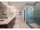 Bright bathroom featuring a vanity, dual sinks and a glass shower enclosure at 2510 Verdello St, Henderson, NV 89044
