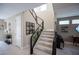 Elegant staircase with carpeted steps, complemented by modern black railings and contemporary art, leading to upper levels at 2510 Verdello St, Henderson, NV 89044
