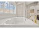 The bathtub features modern fixtures, tile surround, and a bright window at 2608 Sun Reef Rd, Las Vegas, NV 89128