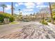 Gated community entrance with brick-paved street, mature trees, and manicured landscaping adding to the luxurious appeal at 2608 Sun Reef Rd, Las Vegas, NV 89128
