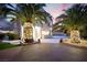 Elegant home with palm trees wrapped in lights and a spacious courtyard in a luxury outdoor setting at 2608 Sun Reef Rd, Las Vegas, NV 89128