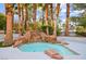 Backyard pool with rock waterfall feature and tropical landscaping, perfect for relaxing at 2608 Sun Reef Rd, Las Vegas, NV 89128