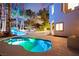 Backyard pool and patio area with a tranquil waterfall feature and lush tropical plants, perfect for relaxation at 2608 Sun Reef Rd, Las Vegas, NV 89128