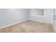 This empty bedroom features neutral carpet and large window with air conditioning unit at 2645 Heritage Ct, Las Vegas, NV 89121