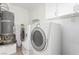 Functional laundry room with washer, dryer, water heater, ironing board, and overhead cabinets at 2645 Heritage Ct, Las Vegas, NV 89121
