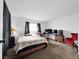 Cozy bedroom with a full bed, red chair, two TVs, and dark decorative curtains at 2761 Phoenix St, Las Vegas, NV 89121