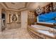 Luxurious bathroom features travertine tile, a soaking tub, and designer finishes at 2845 Red Arrow Dr, Las Vegas, NV 89135