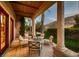 Inviting covered patio with stone columns, comfortable seating, and views of the meticulously manicured lawn at 2845 Red Arrow Dr, Las Vegas, NV 89135