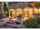 Elegant entrance to a stone house with an arched doorway and decorative wrought iron door at 2845 Red Arrow Dr, Las Vegas, NV 89135