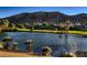 Picturesque golf course with a serene lake, lush greenery, and mountain backdrop at 2845 Red Arrow Dr, Las Vegas, NV 89135