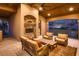 Covered outdoor living area featuring a stone fireplace and comfortable seating with scenic views at 2845 Red Arrow Dr, Las Vegas, NV 89135