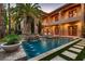 Luxury pool with a stone waterfall feature, flanked by palm trees and lounge chairs at 2845 Red Arrow Dr, Las Vegas, NV 89135