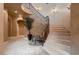 Elegant curved staircase features wrought iron railings, decorative lighting, and a two-story entry at 2845 Red Arrow Dr, Las Vegas, NV 89135