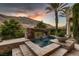 Picturesque rock waterfall cascading into a pool with a serene mountain backdrop at dusk at 2845 Red Arrow Dr, Las Vegas, NV 89135
