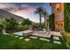 Landscaped backyard featuring a rock waterfall and a distant view of the golf course at 2845 Red Arrow Dr, Las Vegas, NV 89135