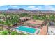 View from above of a community pool, recreation area, clubhouse, and surrounding mountains under a bright, sunny sky at 3000 Morning Ridge Dr, Las Vegas, NV 89134
