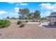Landscaped backyard with a covered patio, desert plants, and mature trees at 3000 Morning Ridge Dr, Las Vegas, NV 89134