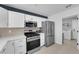 Contemporary kitchen equipped with stainless steel appliances, white cabinetry, and a convenient utility room access at 3000 Morning Ridge Dr, Las Vegas, NV 89134