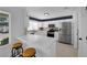 Beautiful white kitchen with marble countertops, stainless steel appliances, and a breakfast bar with stool seating at 3000 Morning Ridge Dr, Las Vegas, NV 89134