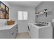 Well-organized laundry room with modern appliances, counter space, and shelving, providing an efficient cleaning space at 3000 Morning Ridge Dr, Las Vegas, NV 89134