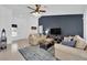 Comfortable living room with stylish furnishings, a dark blue accent wall, and bright, natural light at 3000 Morning Ridge Dr, Las Vegas, NV 89134