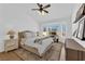 Bright bedroom features a neutral color palette, a ceiling fan, a bay window, and a writing desk at 3000 Morning Ridge Dr, Las Vegas, NV 89134