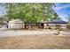 Home exterior featuring a spacious driveway, attached garage, and mature shade trees at 3100 Garehime St, Las Vegas, NV 89108