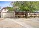 Front view of single story home featuring mature trees, large driveway, and solar panels at 3100 Garehime St, Las Vegas, NV 89108