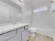 Well-lit bathroom showcases a sink with grey cabinets, tiled floors, a toilet and shower with white tiling at 3444 Trilogy Dr, Las Vegas, NV 89108