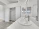 Bathroom featuring double sinks with white countertops, tiled floors, and framed mirrors with modern vanity lighting at 3444 Trilogy Dr, Las Vegas, NV 89108