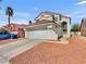 Home exterior featuring a two-car garage, desert landscaping, concrete driveway and pathway at 3444 Trilogy Dr, Las Vegas, NV 89108