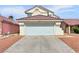 Home with a two car garage, red tiled roof, desert rock landscaping, and concrete driveway at 3444 Trilogy Dr, Las Vegas, NV 89108