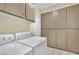 Well-organized laundry room featuring a white washer and dryer and ample cabinet space for storage at 3755 Broadmead St, Las Vegas, NV 89147