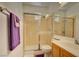 Bright bathroom featuring a glass shower enclosure, toilet, vanity with sink, and neutral wall tile at 3840 Belle Glade St # 104, Las Vegas, NV 89129